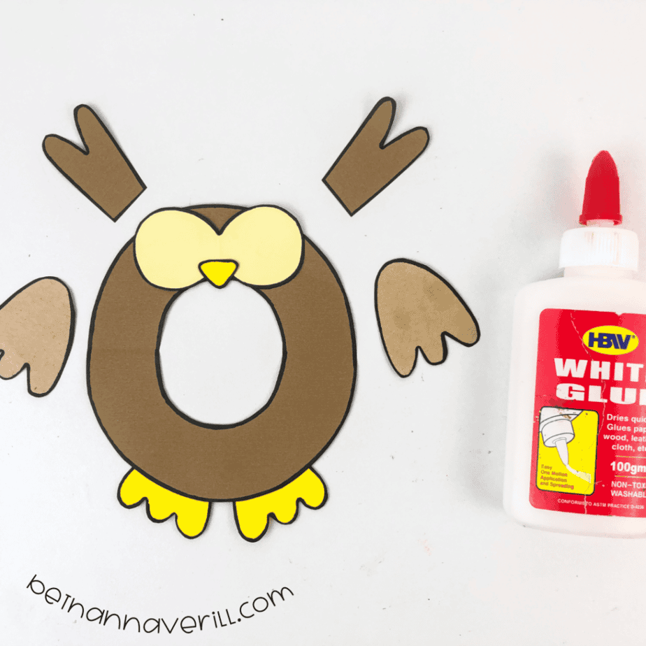 Dark brown lowercase o with beige face, yellow beak and yellow feet