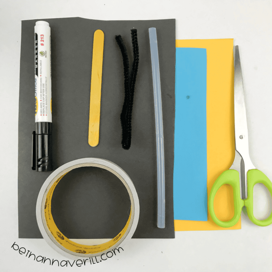 Black, yellow and blue construction paper, a popsicle stick, fuzzy wire, double-sided tape, a marker and scissors