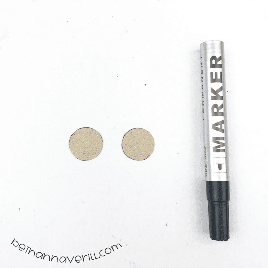 Two tan paper circles next to a black marker