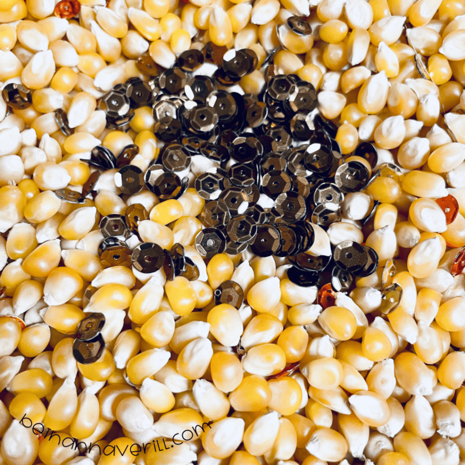 Gold and orange sequins mixed into popcorn kernels