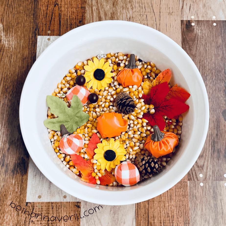 Fall sensory bin with sunflowers, pumpkins and leaves