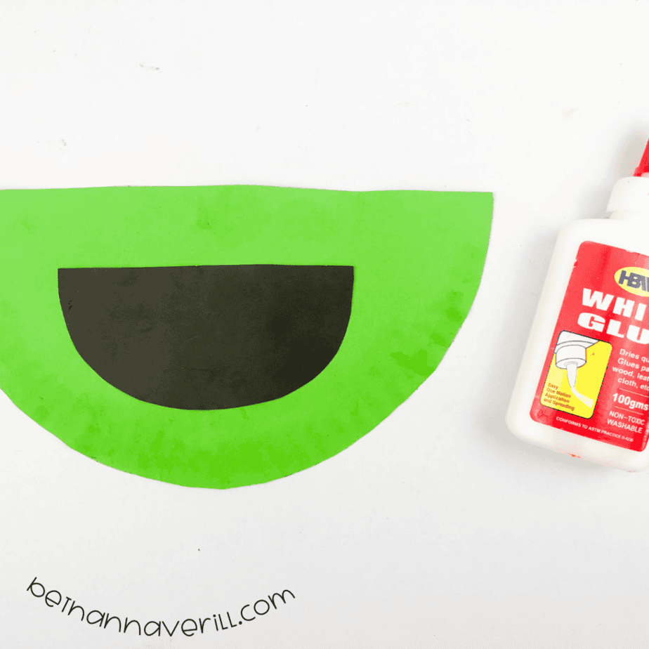 Black half circle mouth glued to the green plate
