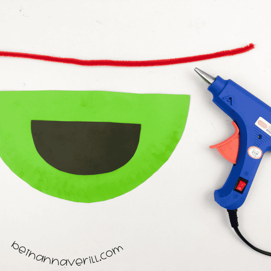 Red fuzzy wire laid above the green plate and black mouth