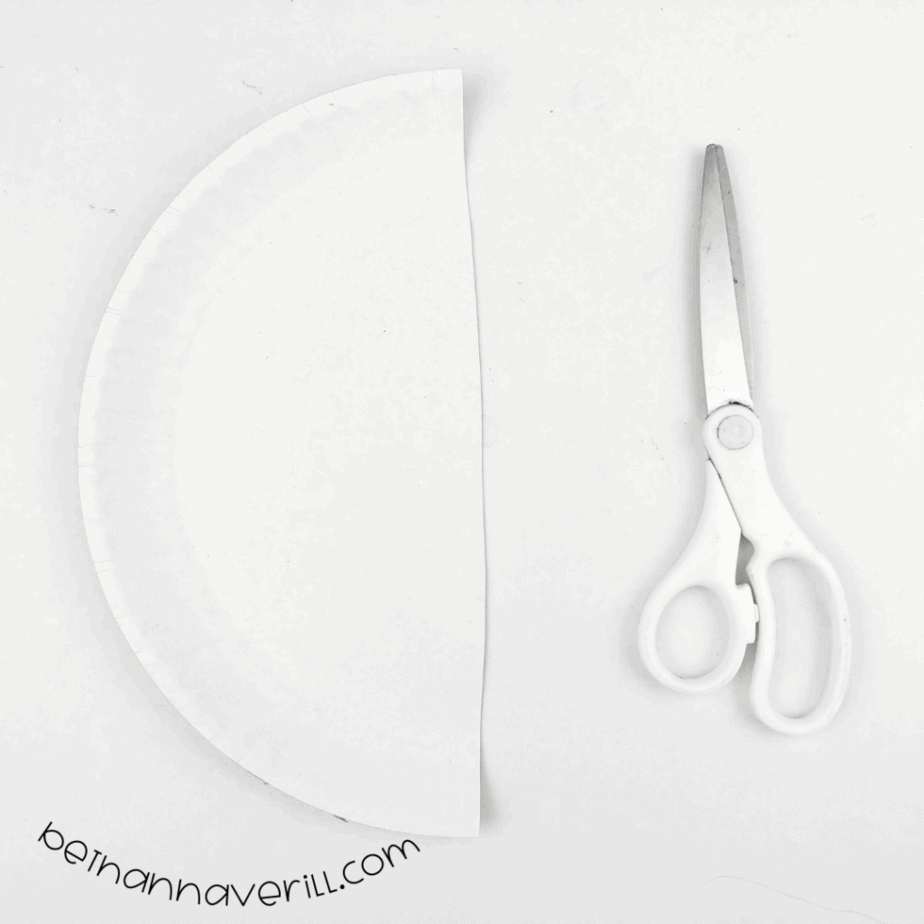Paper plate cut in half next to scissors
