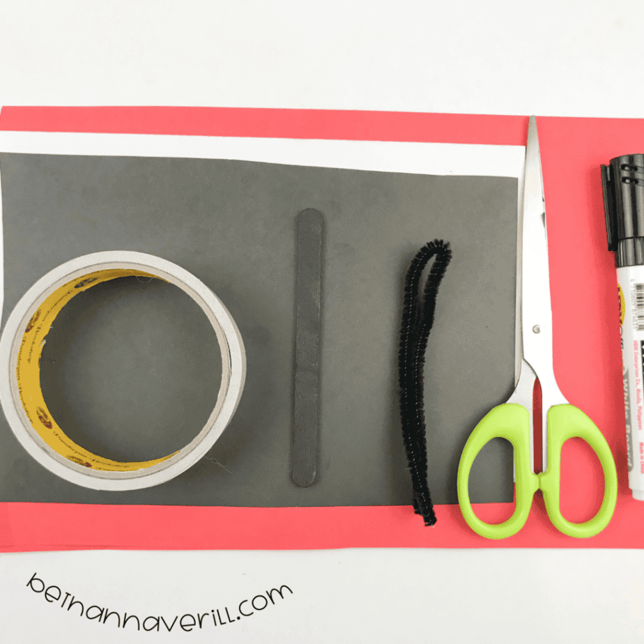 Red, black and white construction paper, double-sided tape, a marker, fuzzy wire and scissors
