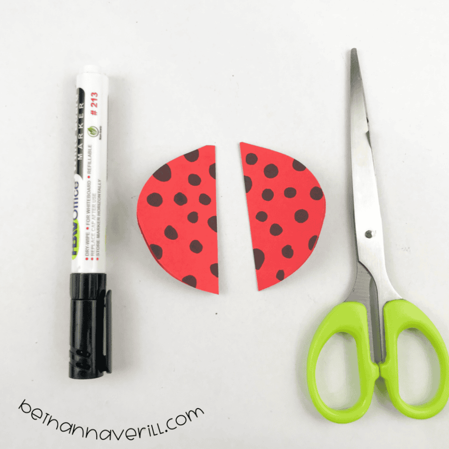 Red paper circle with black marker dots cut into two wing halves