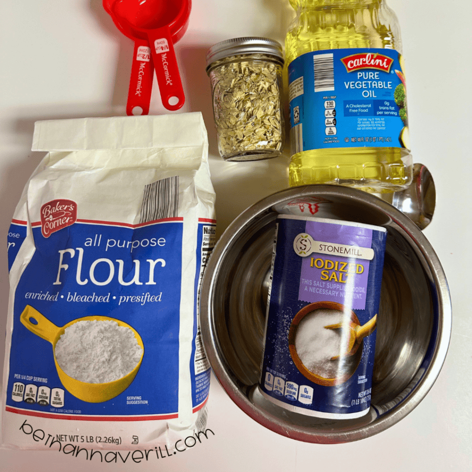 Oatmeal playdough supplies including flour, salt, oats, vegetable oil, and measuring cups