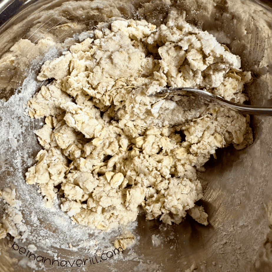 Oatmeal playdough coming together in a metal mixing bowl