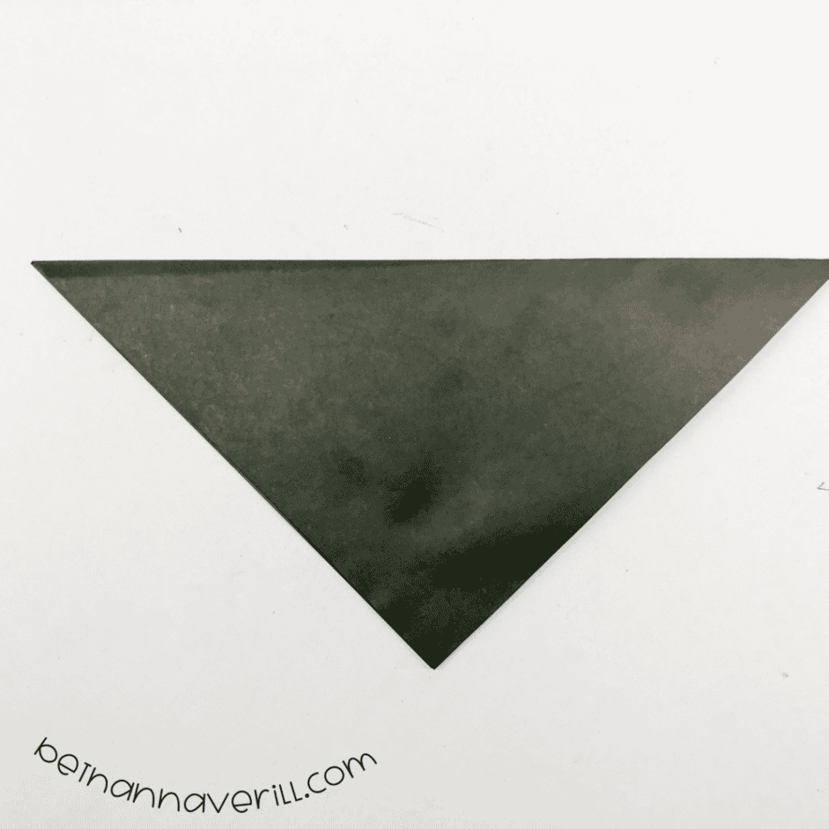 Black square of paper folded into a triangle