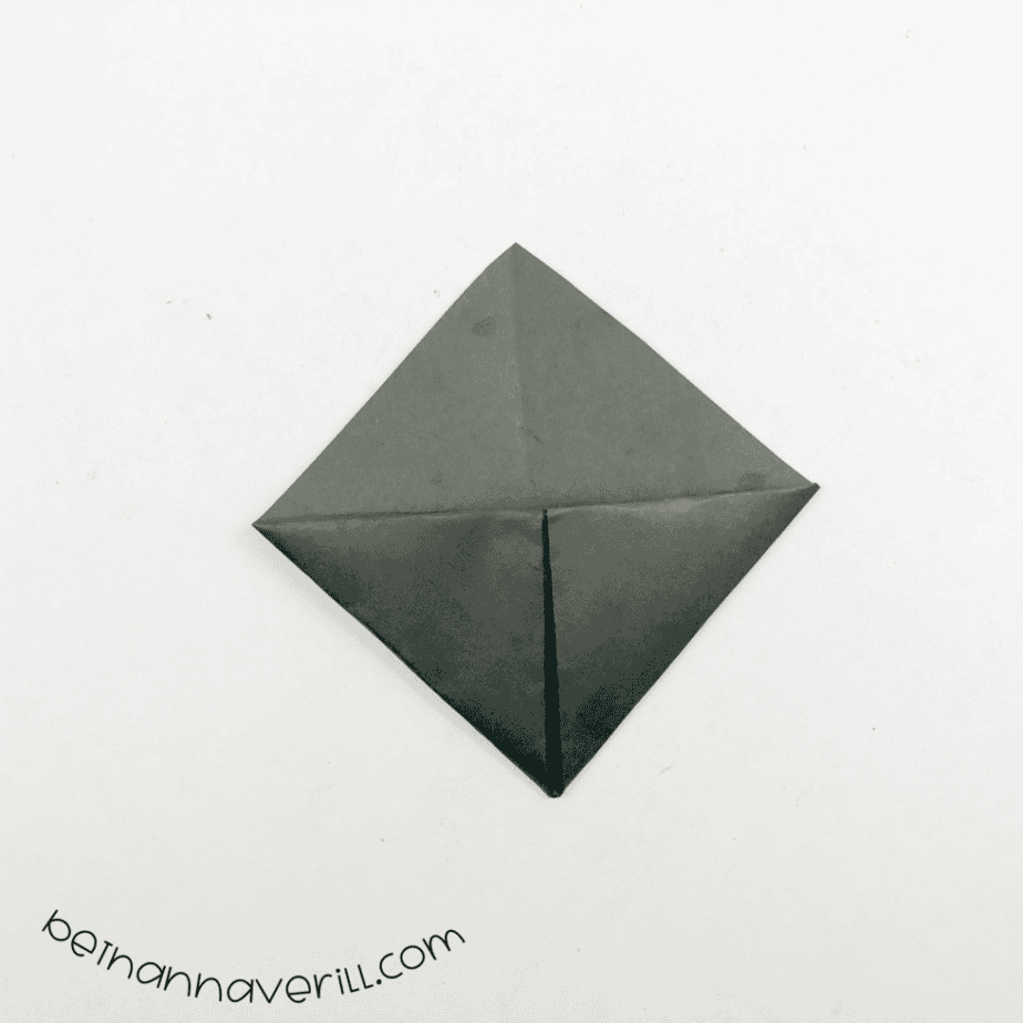 Black origami bookmark folded into a diamond pocket