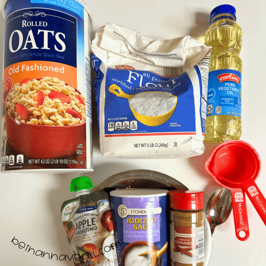 Cinnamon applesauce playdough supplies including oats, flour, salt, vegetable oil, applesauce, cinnamon, and measuring cups