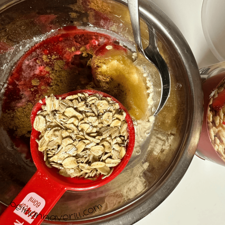 Measuring cup of oats added to the cinnamon applesauce playdough