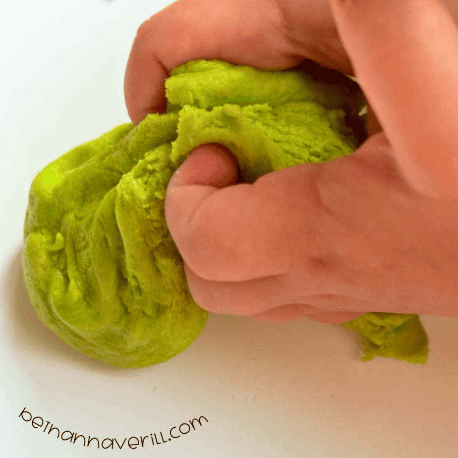 Hand squeezing soft green apple playdough