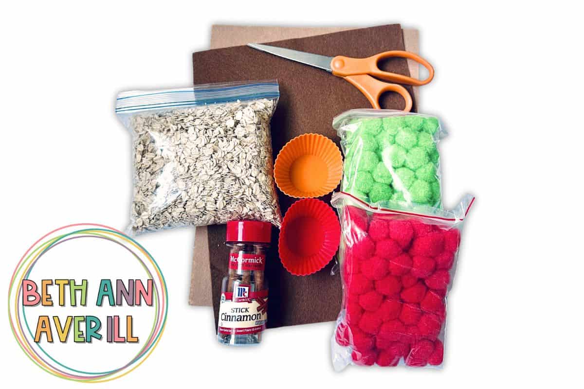 supplies for apple pie sensory bin, oats, red and green pom poms, cinnamon sticks, and felt.