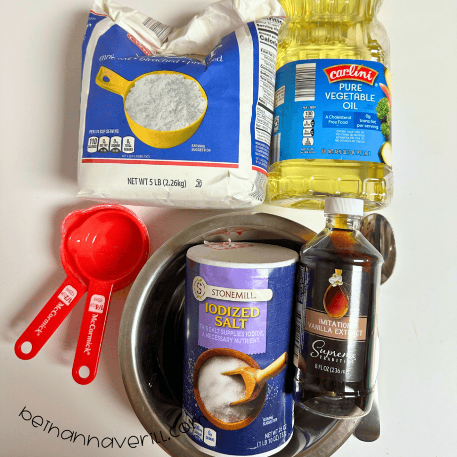 Vanilla playdough supplies including flour, salt, vegetable oil, vanilla extract, and measuring cups