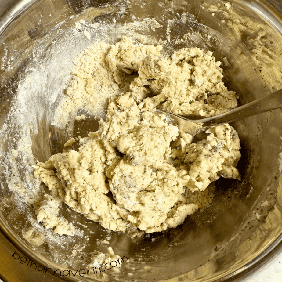 Speckled green tea playdough being mixed together in a metal bowl