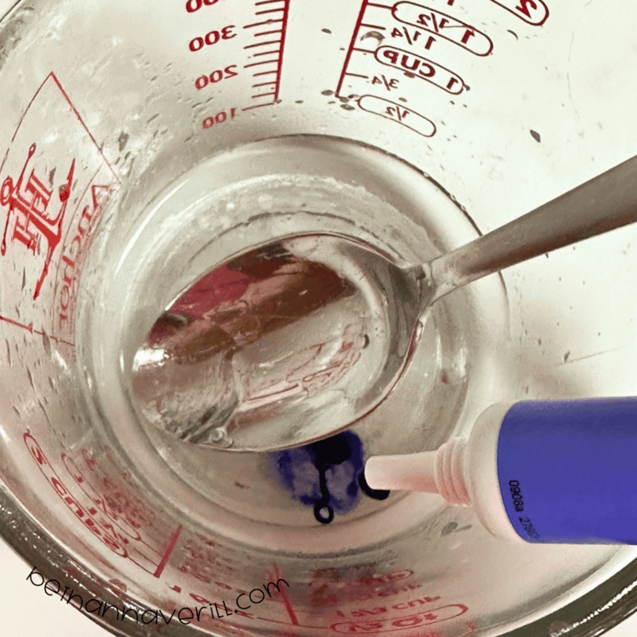 Purple food coloring stirred into a measuring cup of water