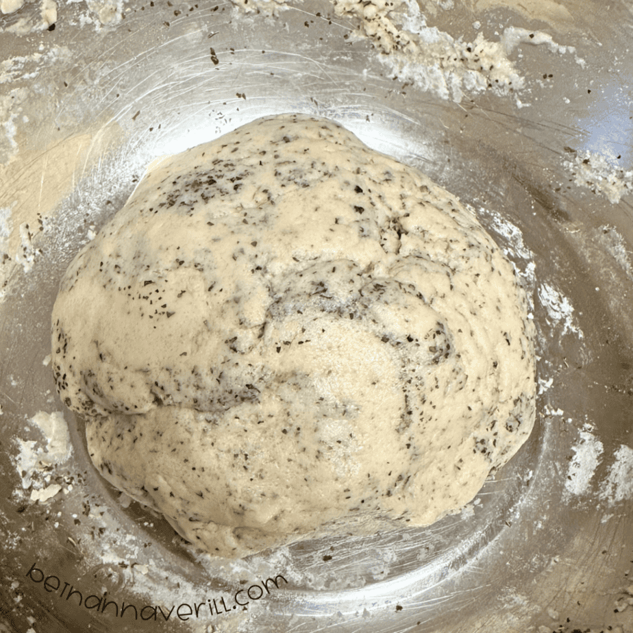 Smooth ball of speckled peppermint tea playdough in a metal mixing bowl