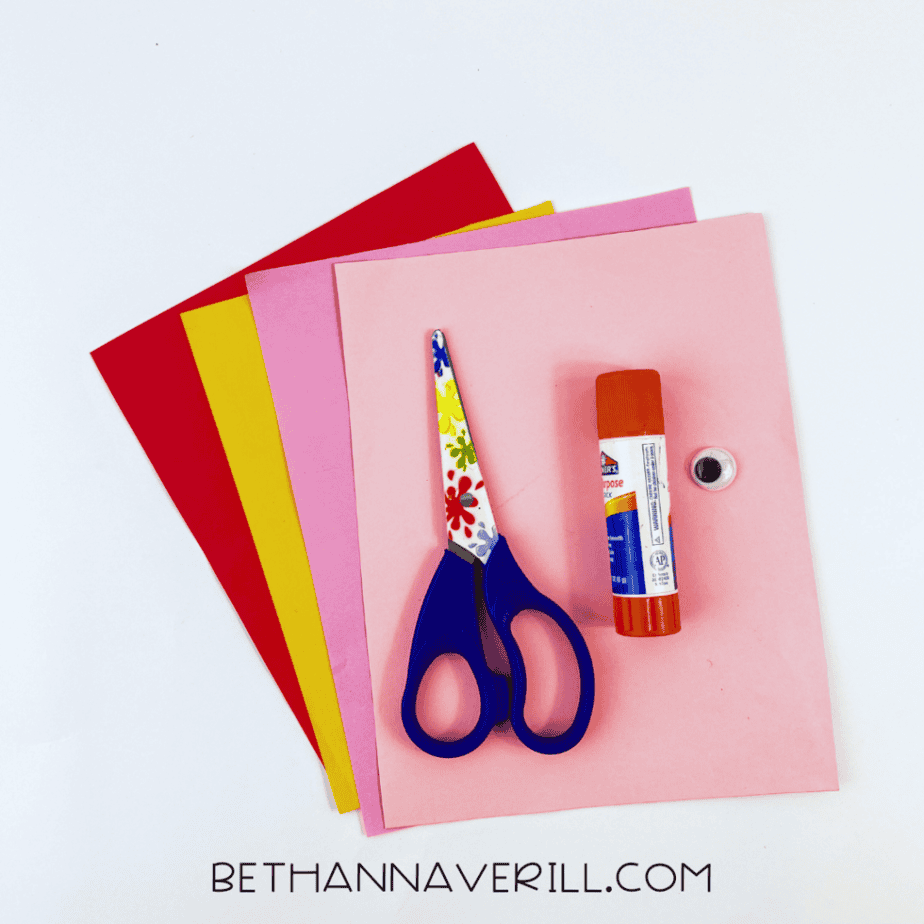 Valentine ostrich supplies: red, pink and yellow paper, googly eye, glue stick and scissors