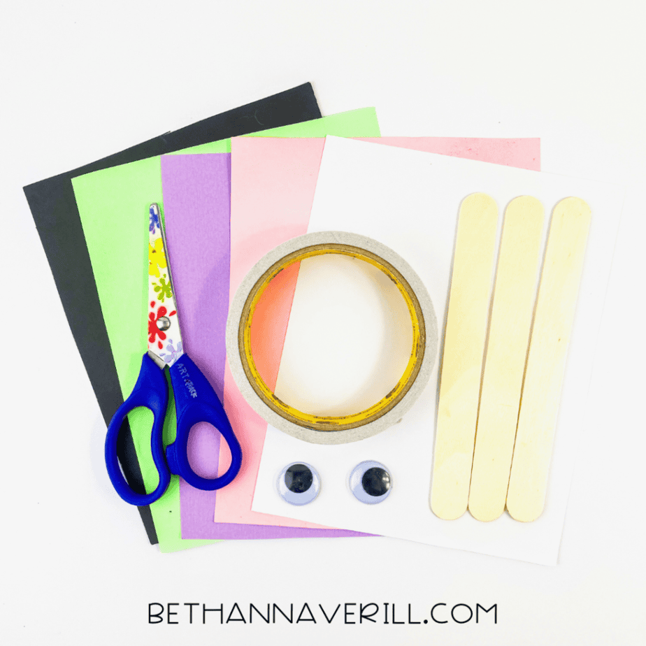 Bunny craft supplies: popsicle sticks, colored paper, googly eyes, tape and scissors