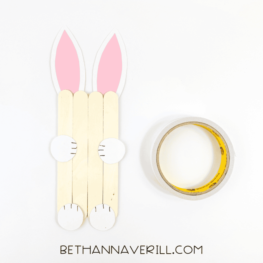 White paws glued to the sides of the popsicle stick bunny