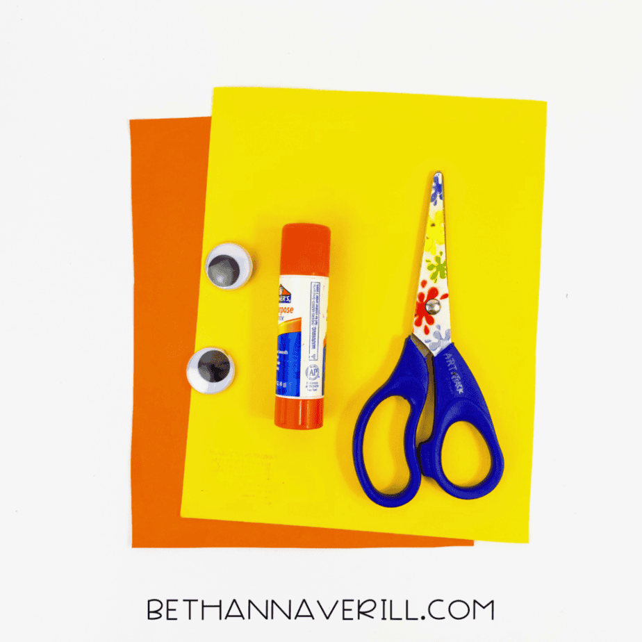 Handprint chick supplies: yellow and orange paper, googly eyes, glue stick and scissors