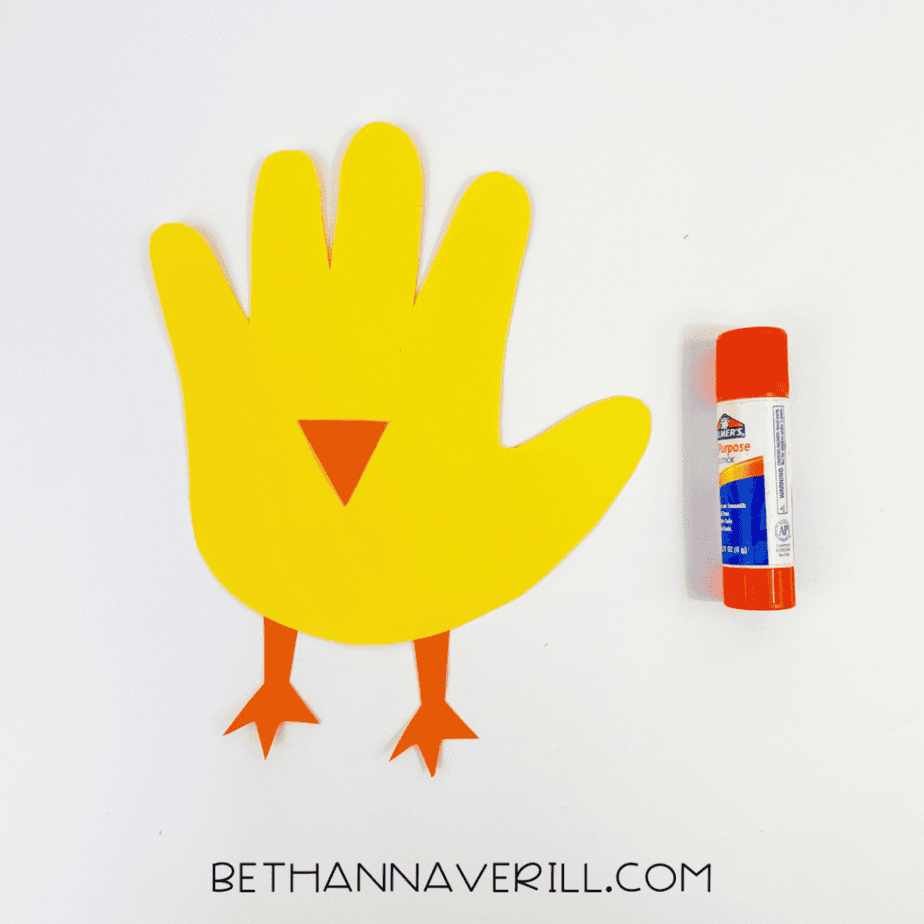 Orange feet and beak glued onto the yellow handprint
