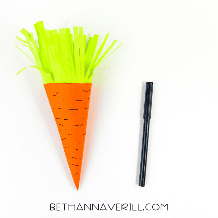 Black marker lines drawn on the paper carrot