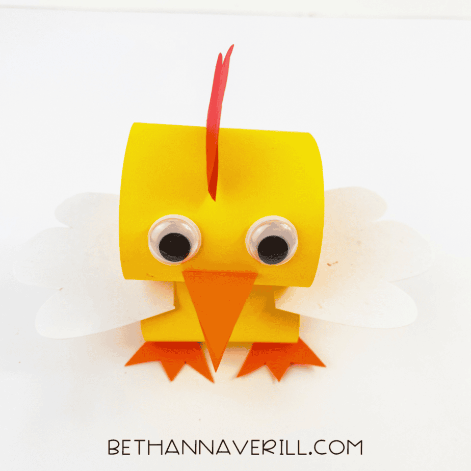 Finished paper chick craft with googly eyes, red comb and white wings