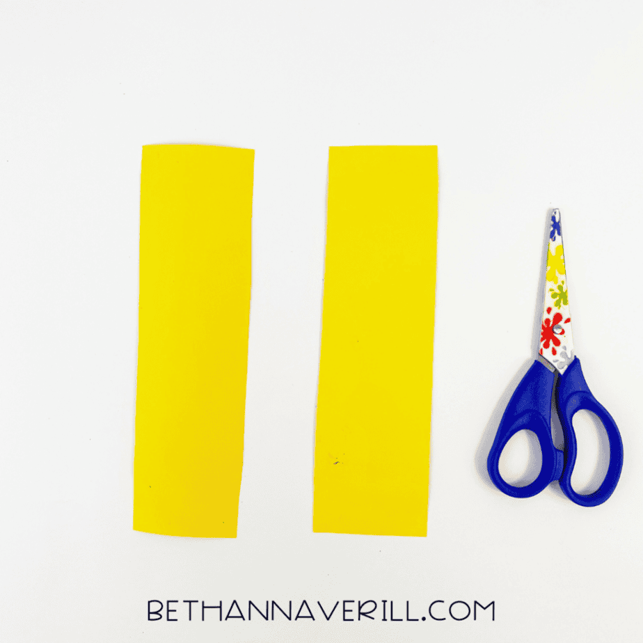 Two yellow paper strips next to scissors