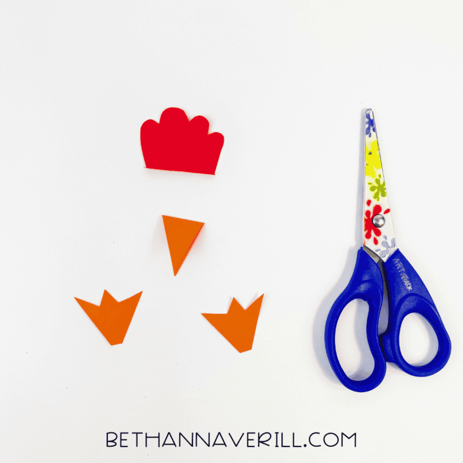 Red comb, orange beak and orange feet cut from paper