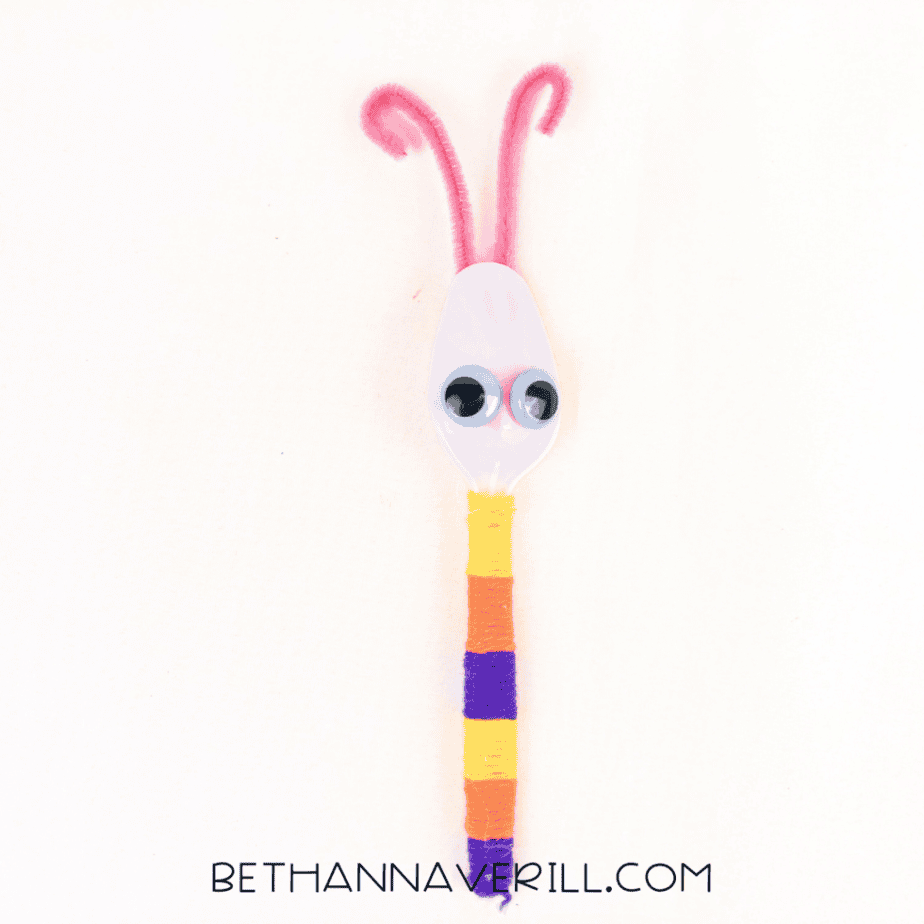 Googly eyes and pipe cleaner antennae added to the spoon