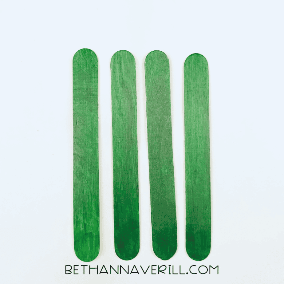 Four craft sticks painted green
