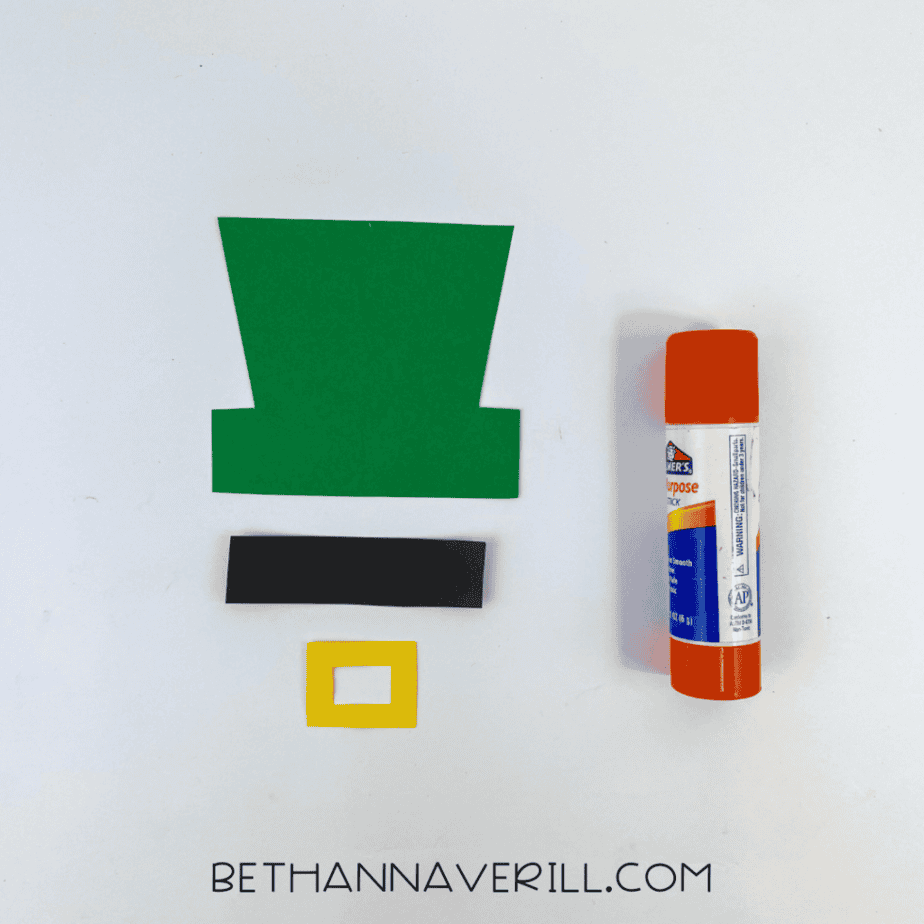 Green top hat, black band and yellow buckle cut from paper