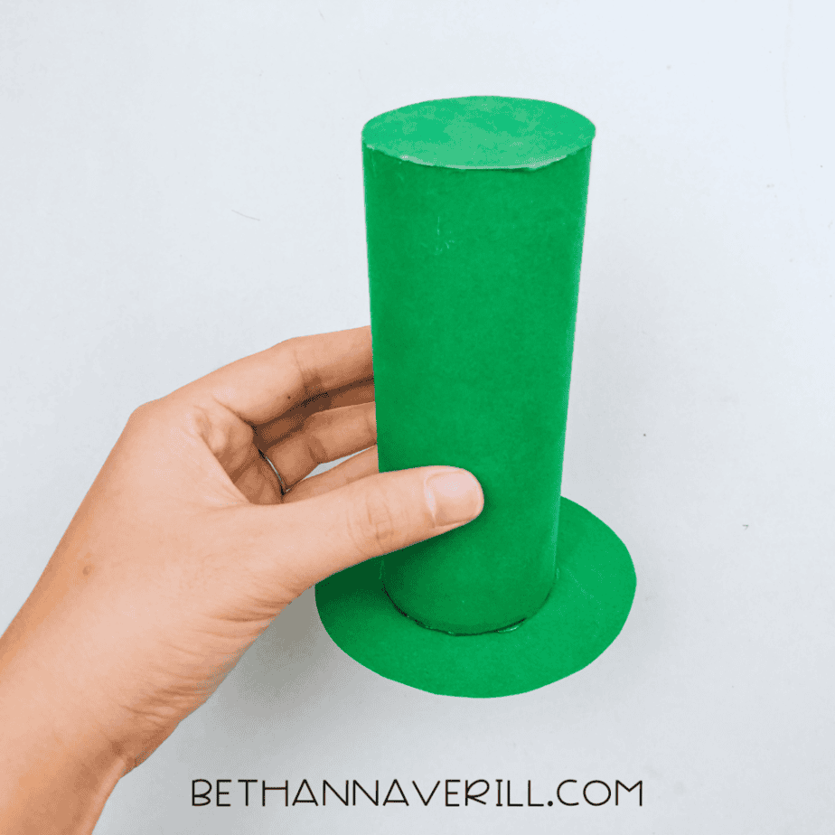 Green hat with brim held in a hand
