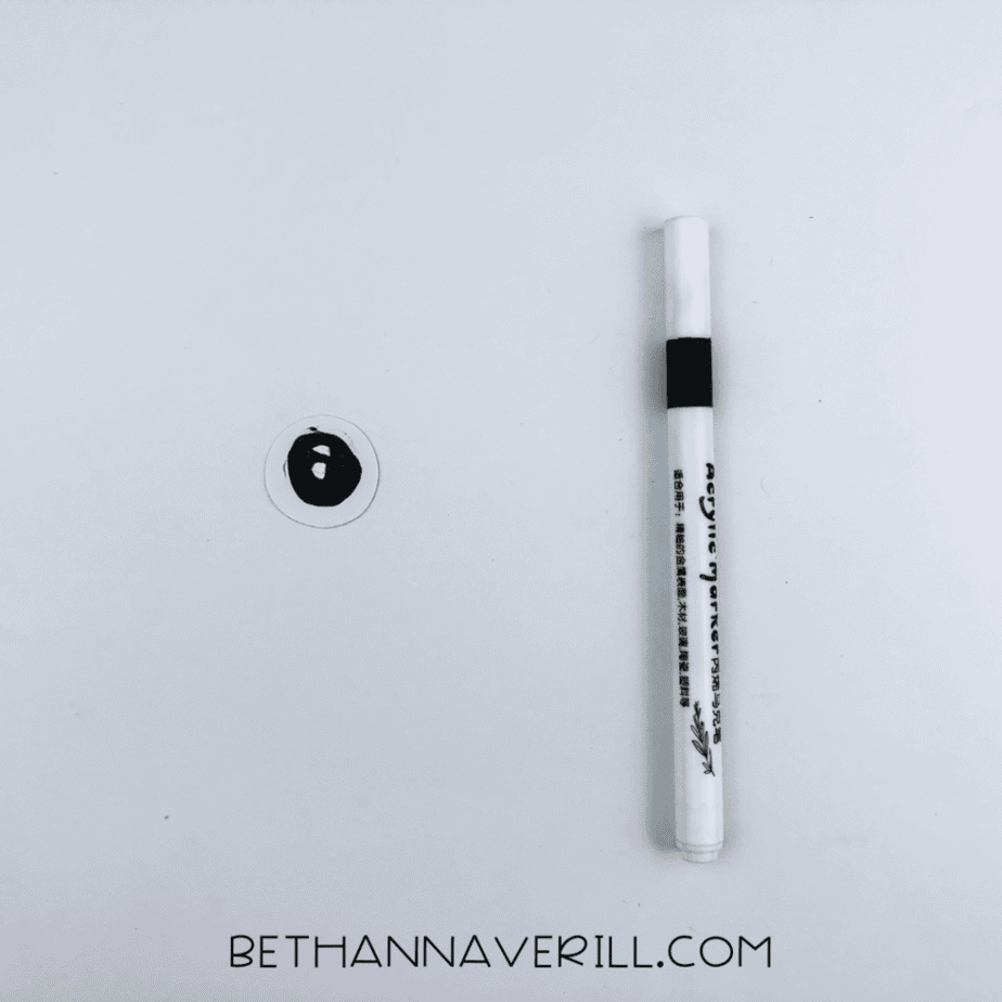 White paper eye next to a black marker