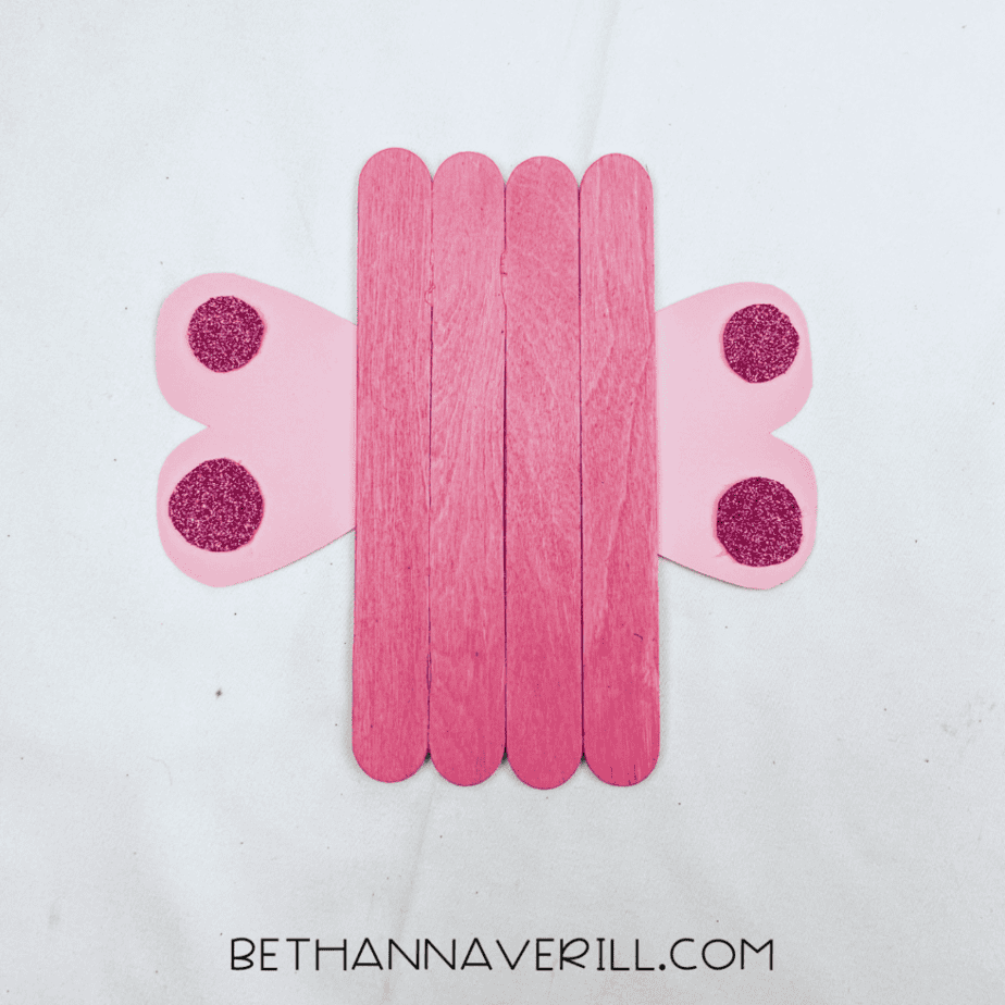 Wings glued to the pink craft stick body