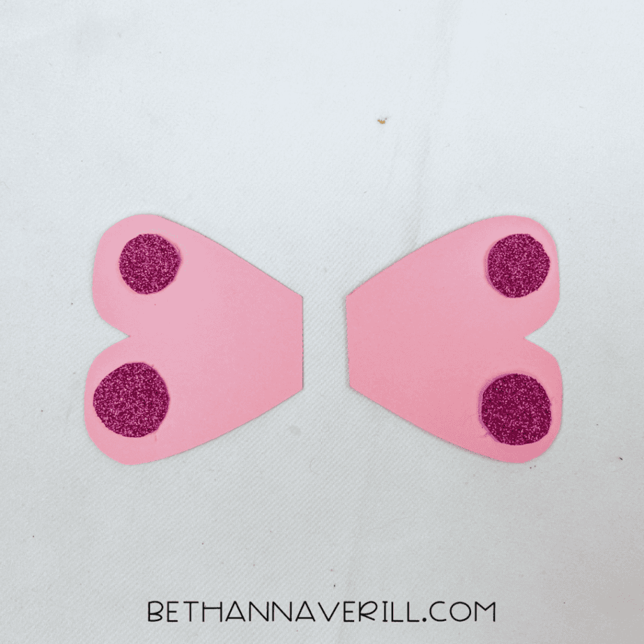 Sparkly circles glued onto the pink wings
