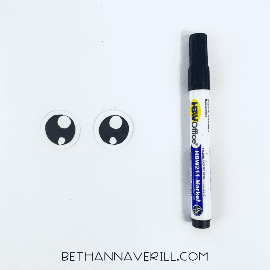 Paper eyes next to a black marker