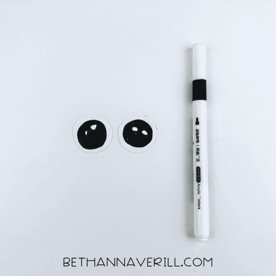 Paper eyes next to a black marker