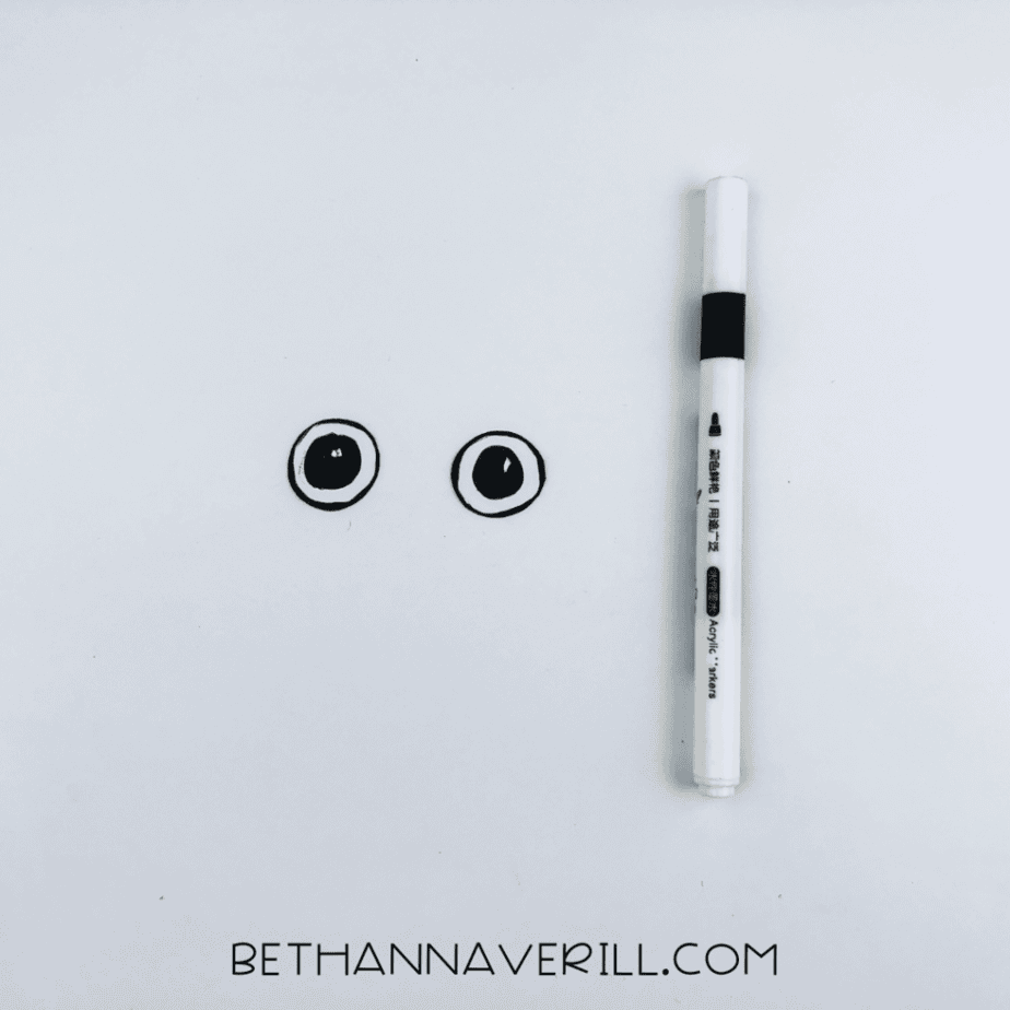 Paper eyes next to a black marker