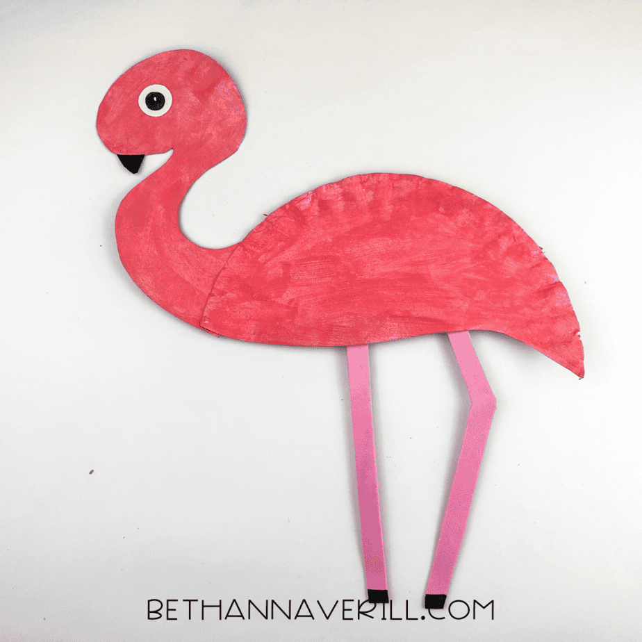 A flamingo with a full eye and black pupil, standing tall with its paper plate body and pink legs.