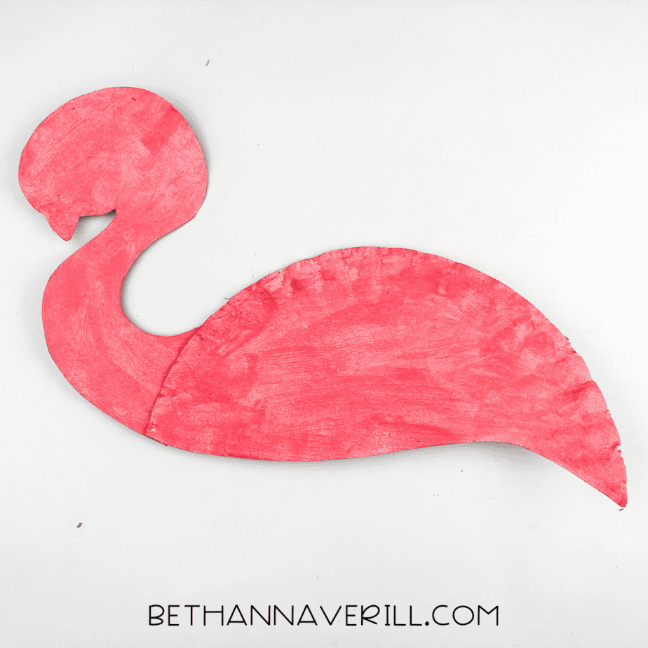 The painted flamingo head and body pieces glued together, starting to look like a bird.