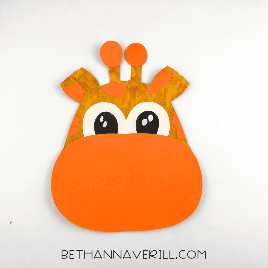 The giraffe's face with added orange circles glued to the top of the ossicones.