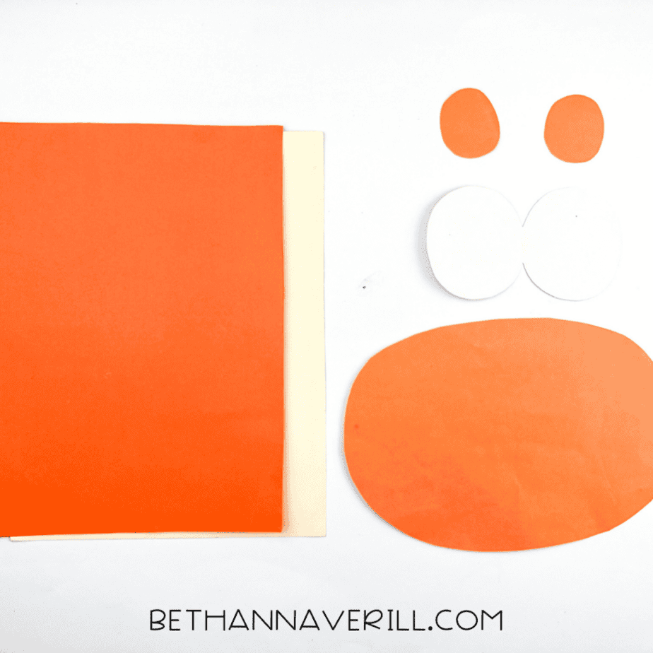 Orange and cream construction paper cut into shapes for the giraffe’s eyes, muzzle, and spots.