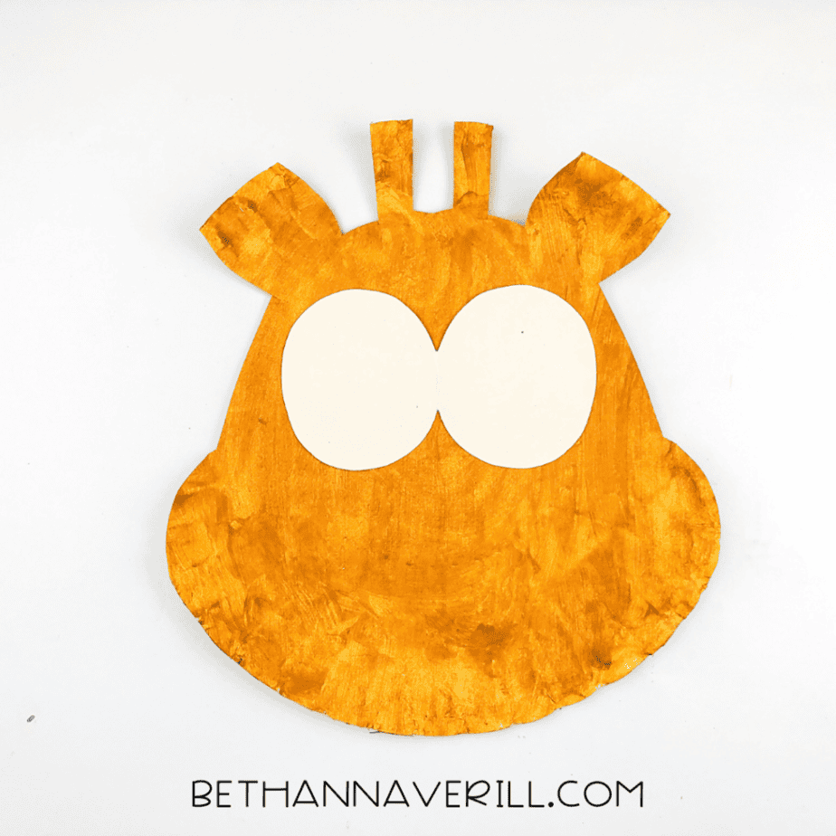 Two cream ovals glued onto the giraffe head to create the eyes.