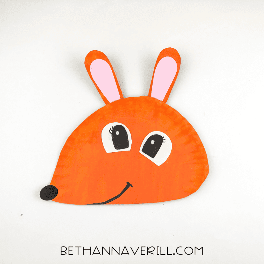 Finished kangaroo paper plate craft with big cartoon eyes, pink ears, and a curved smile drawn on