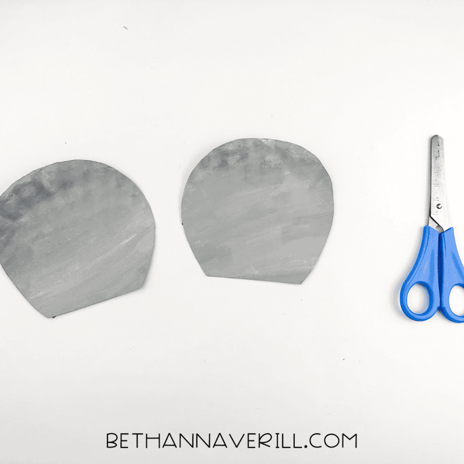 Second painted plate cut in half to create two curved koala ear shapes.