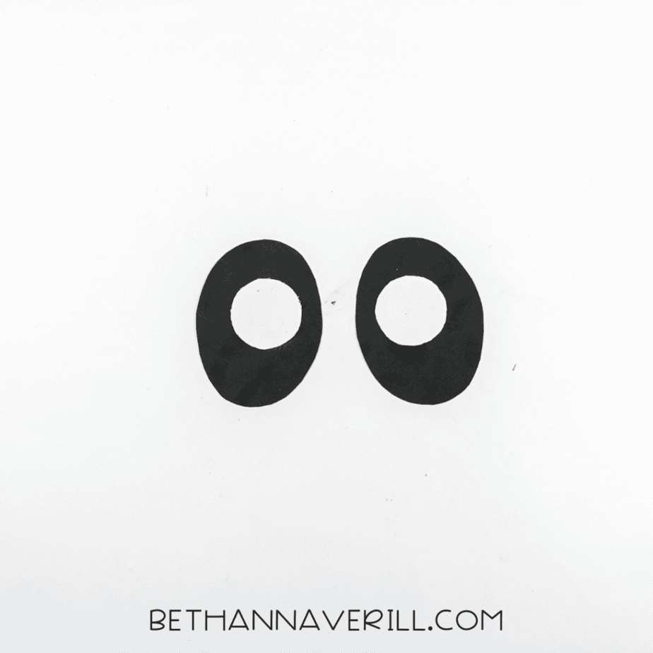 Two black ovals with smaller white circles centered on top, placed side by side.