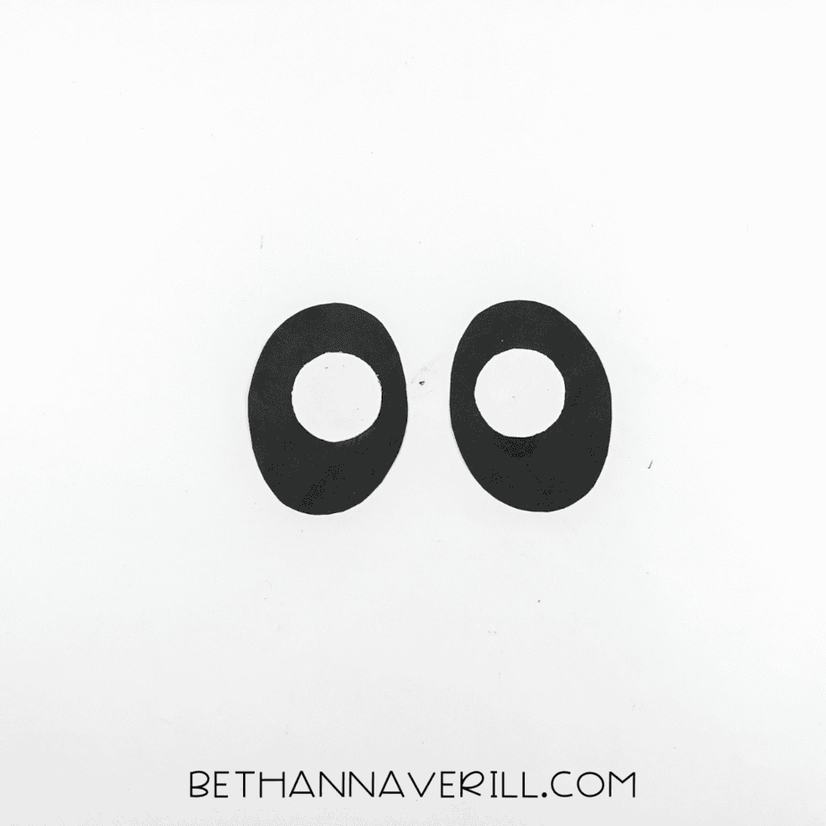 Two black ovals with smaller white circles centered on top, placed side by side.